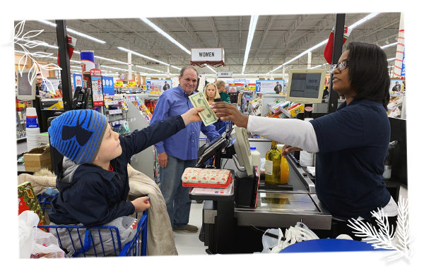 young child handing twenty dollar bill to cashier in store check out