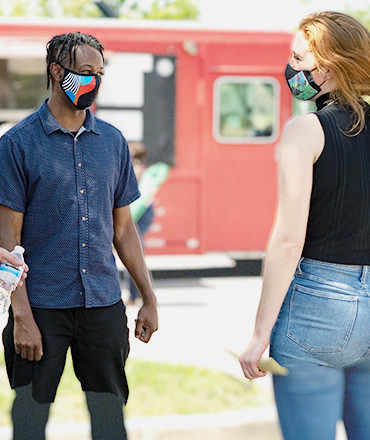 Mx employees chatting outside while wearing masks
