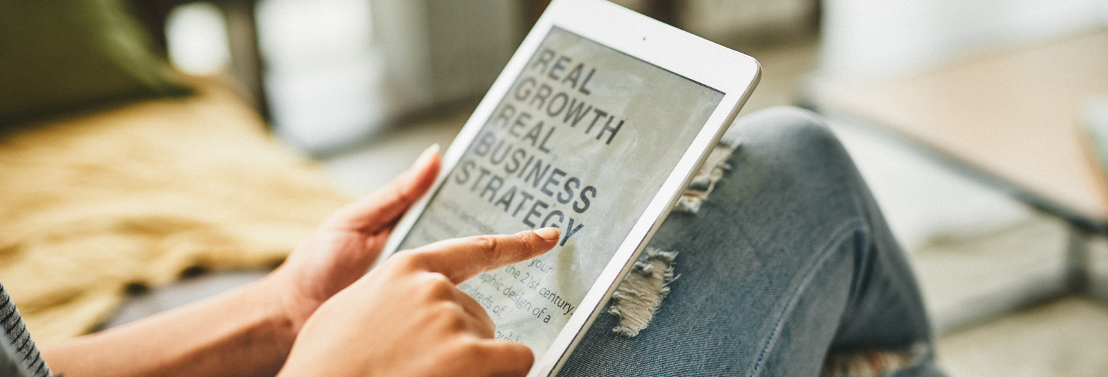 person interacting with a tablet that says real growth real business strategy